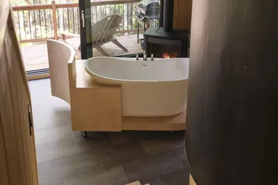 a bathroom with a bath tub and a fireplace at Cabin Zoobox 69 in Eastman