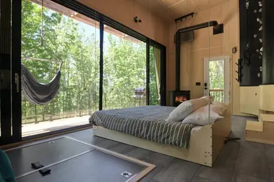 a bedroom with a bed and a large window at Cabin Zoobox 73 in Eastman