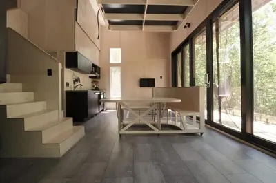 a living room with a table and a staircase at Cabin Zoobox 73 in Eastman