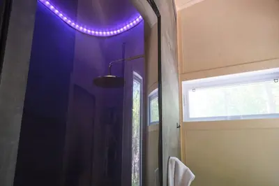 a bathroom with a purple light on the ceiling at Cabin Zoobox 74 in Eastman