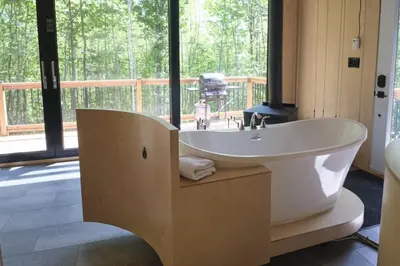 a large white tub in a bathroom with a deck at Cabin Zoobox 75 in Eastman