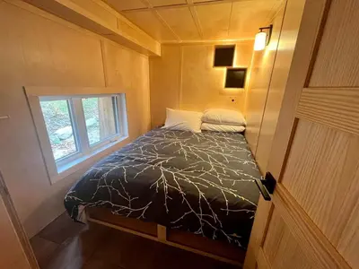 a bed in a small room with a window at Cabin Zoobox 76 in Eastman