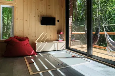 a living room with a large window and a tv at Cabin Zoobox 78 in Eastman