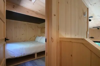 a bedroom with a bed in a wooden cabin at Cabin Zoobox 78 in Eastman
