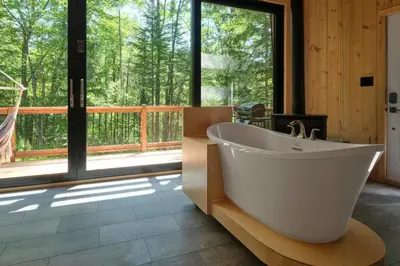 a large bathroom with a tub and a large window at Cabin Zoobox 78 in Eastman