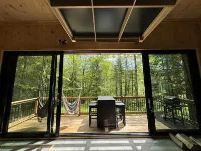 a screened in porch with a view of the woods at Cabin Zoobox 78 in Eastman