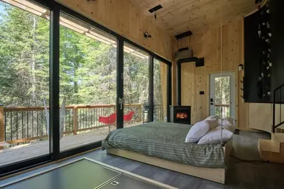 a bedroom with a bed and a fireplace and windows at Cabin Zoobox 89 in Eastman