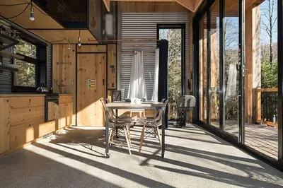 a dining room with a table and chairs on a porch at Cabin Zoobox 55 in Eastman
