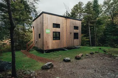a wooden building in the middle of a forest at Cabin Zoobox 88 in Eastman