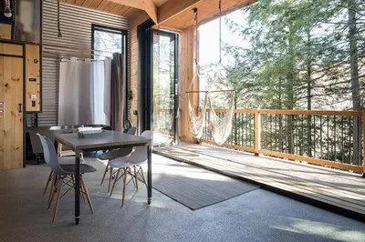a dining room with a table and chairs on a balcony at Cabin Zoobox 65 in Eastman