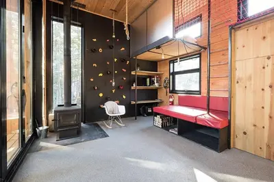 a gym with a rock wall and a red bench at Cabin Zoobox 66 in Eastman