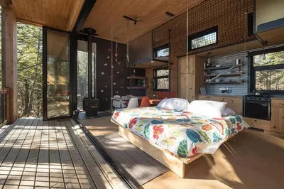 a bedroom with a bed in the middle of a room at Cabin Zoobox 67 in Eastman
