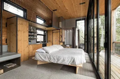 a bedroom with a bed in a room with windows at Cabin Zoobox 68 in Eastman