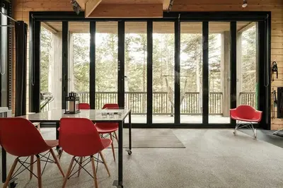 a dining room with red chairs and a table at Cabin Zoobox 82 in Eastman