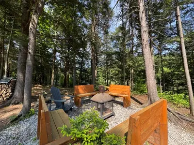 a backyard with a table and chairs in the woods at Cabin Zoobox 82 in Eastman