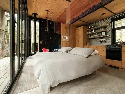 a bedroom with a large bed in a room with windows at Cabin Zoobox 82 in Eastman