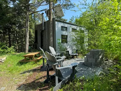 a group of chairs and tables in front of a building at Cabin Zoobox 84 in Eastman