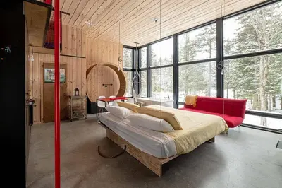 a bedroom with a large bed in a room with windows at Cabin Zoobox 87 in Eastman