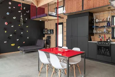 a room with a dining table and a climbing wall at Cabin Zoobox 87 in Eastman