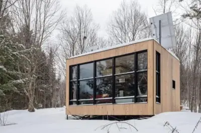a small house with glass windows in the snow at Cabin Zoobox 87 in Eastman