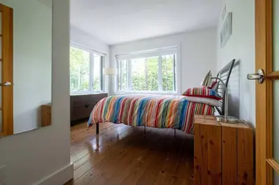a bedroom with a bed with a colorful blanket at Cottage 35 Chemin Gilbert in Eastman
