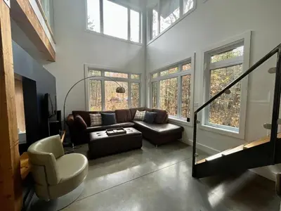 a living room with a couch and a chair at Cottage 61 des Cervidés in Eastman