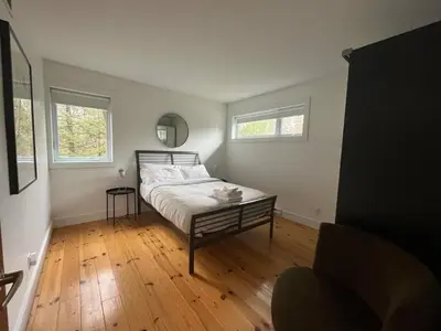 a bedroom with a bed and a chair in it at Cottage 61 des Cervidés in Eastman