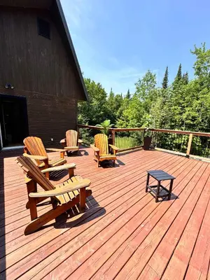 a wooden deck with benches and a table on it at Cottage 61 des Cervidés in Eastman