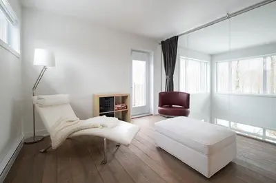 a white living room with a couch and a chair at Cottage 2 de la Chute in Eastman