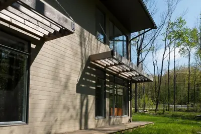 a house with awning on the side of it at Cottage 2 de la Chute in Eastman