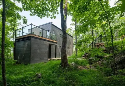 a house in the middle of a forest at Cottage 121 chemin Gilbert in Eastman