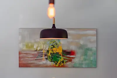 a chandelier hanging from a wall with a painting at Cottage 18 place de la Réserve in Eastman