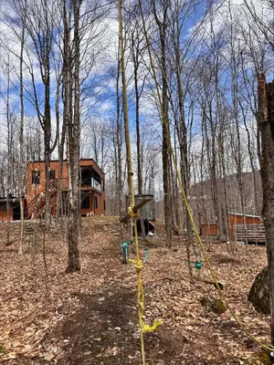 a swing set in the middle of a forest at Cottage 18 place de la Réserve in Eastman