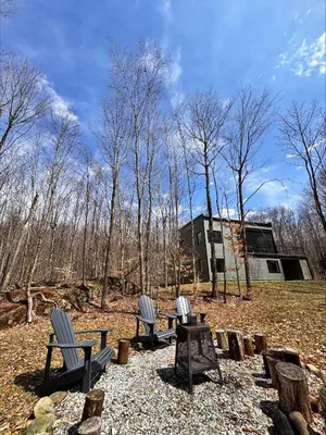 three chairs and a picnic table in a park at Cottage 42 de la Réserve in Eastman