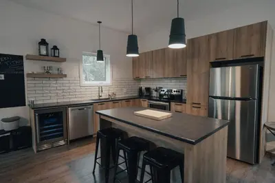 a kitchen with a large island with a refrigerator at Cottage 42 de la Réserve in Eastman