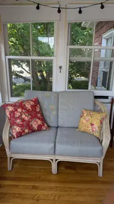 a couch with two pillows sitting in front of a window at Gîte Richmond Inn in Richmond