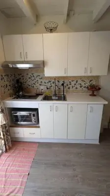 a kitchen with white cabinets and a microwave at Gîte Richmond Inn in Richmond
