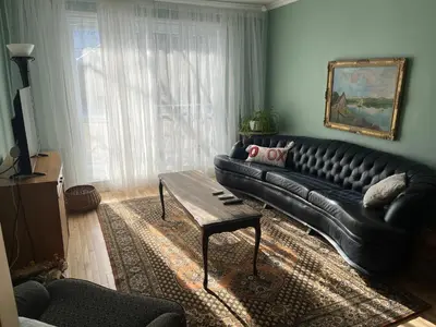 a living room with a black leather couch and a table at Smiling house! 2 chambres, accueillant et spacieux in Montréal
