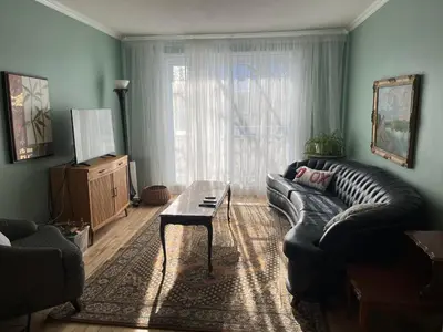 a living room with a leather couch and a table at Smiling house! 2 chambres, accueillant et spacieux in Montréal