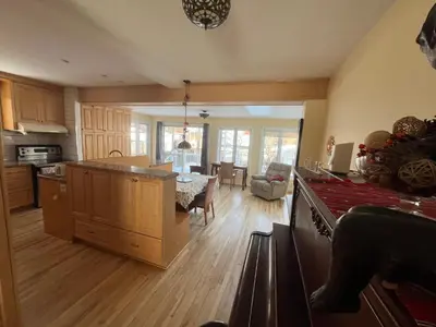 a kitchen and living room with a table and a dining room at Smiling house! 2 chambres, accueillant et spacieux in Montréal