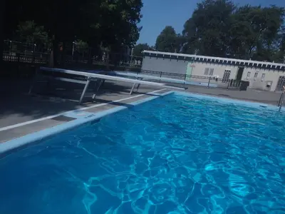 a large blue swimming pool in front of a building at Smiling house! 2 chambres, accueillant et spacieux in Montréal