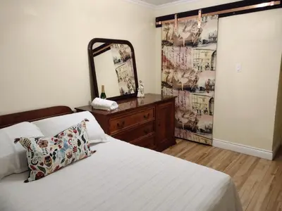 a bedroom with a bed with a mirror and a dresser at Smiling house! 2 chambres, accueillant et spacieux in Montréal