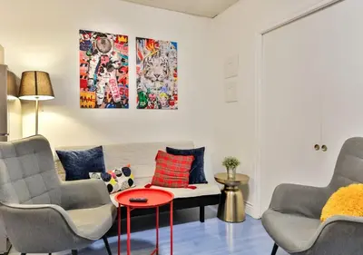 a living room with two chairs and a red table at 100 METERS to METRO BEAUDRY - FULL APARTMENTS - 1 minute walk to the FAMOUS ST CATHERINE STREET - FAST WIFI - WASHER & DRYER ON SITE - Montcalm units in Montréal