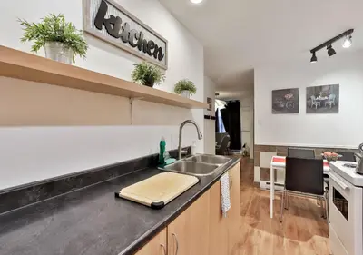 a kitchen with a sink and a counter top at 100 METERS to METRO BEAUDRY - FULL APARTMENTS - 1 minute walk to the FAMOUS ST CATHERINE STREET - FAST WIFI - WASHER & DRYER ON SITE - Montcalm units in Montréal