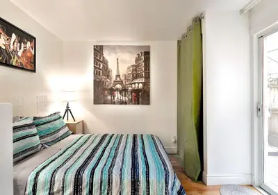 a bedroom with a bed and a painting on the wall at 100 METERS to METRO BEAUDRY - FULL APARTMENTS - 1 minute walk to the FAMOUS ST CATHERINE STREET - FAST WIFI - WASHER & DRYER ON SITE - Montcalm units in Montréal