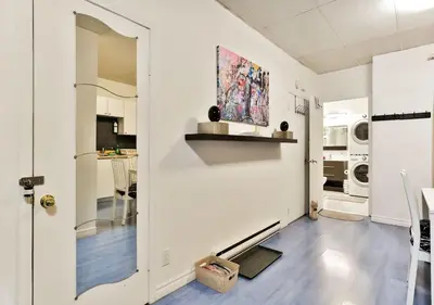 a living room with white walls and a kitchen at 100 METERS to METRO BEAUDRY - FULL APARTMENTS - 1 minute walk to the FAMOUS ST CATHERINE STREET - FAST WIFI - WASHER & DRYER ON SITE - Montcalm units in Montréal