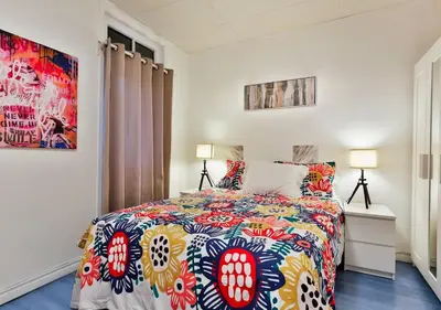 a bedroom with a bed with a colorful bedspread at 100 METERS to METRO BEAUDRY - FULL APARTMENTS - 1 minute walk to the FAMOUS ST CATHERINE STREET - FAST WIFI - WASHER & DRYER ON SITE - Montcalm units in Montréal