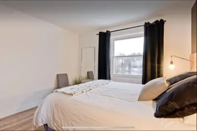 a bedroom with a large bed with a window at Cap Magog! Près du lac Memphrémagog et Mont Orford in Magog-Orford