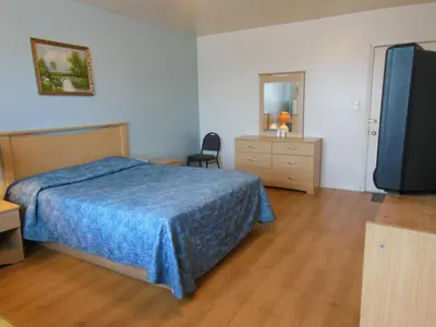a hotel room with a bed and a television at Motel Pierre in Montréal