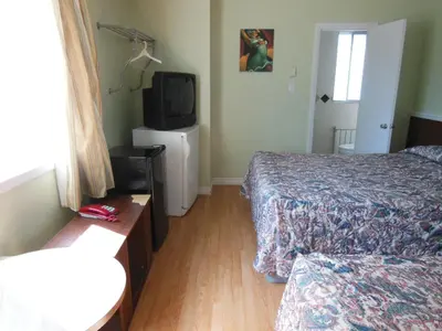 a hotel room with two beds and a television at Motel Pierre in Montréal